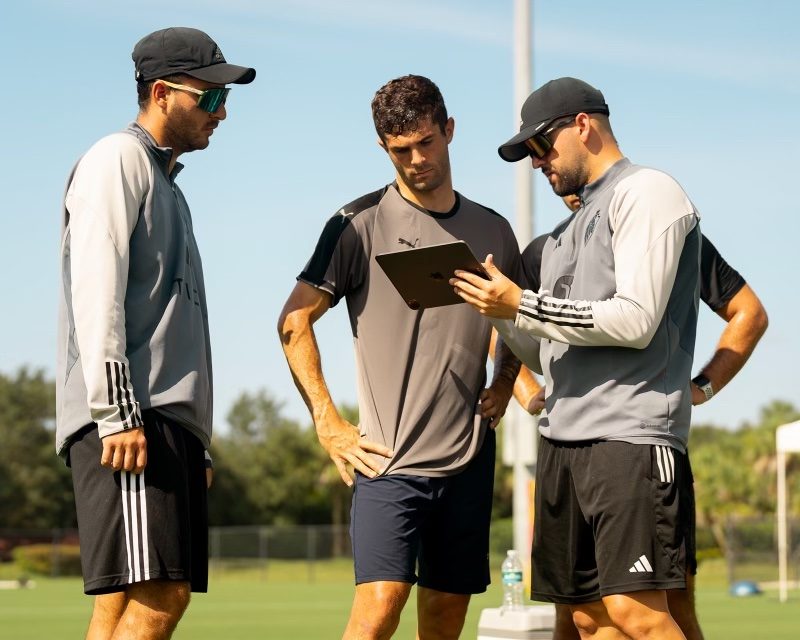 SAT Soccer coaches reviewing analysis with a pro player